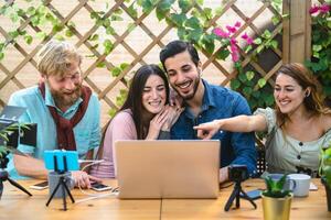 joven amigos rodaje vídeo vlog para en línea web canal - contento milenario personas teniendo divertido haciendo En Vivo corriente utilizando teléfono inteligente leva y computadora - juventud Generacion z y tecnología concepto foto