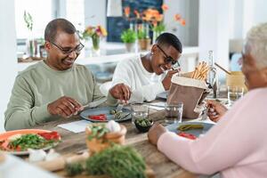 contento afro latín familia comiendo sano almuerzo con Fresco vegetales a hogar - comida y padres unidad concepto foto