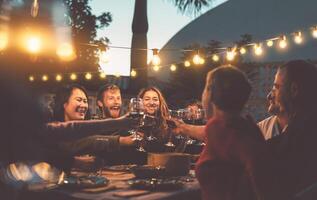 contento familia comida y saboreo rojo vino lentes en parilla cena fiesta - personas con diferente siglos y etnia teniendo divertido juntos - juventud y mayor padres y comida fin de semana ocupaciones concepto foto