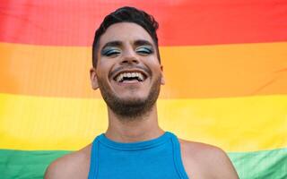 contento homosexual hombre celebrando gay orgullo participación arco iris bandera símbolo de lgbtq comunidad foto