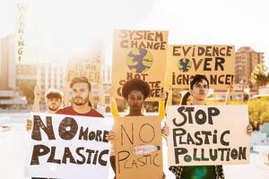 grupo manifestantes protestando en contra el plastico contaminación y clima cambio - multirracial personas luchando en la carretera participación pancartas en ambientes desastres - global calentamiento concepto foto