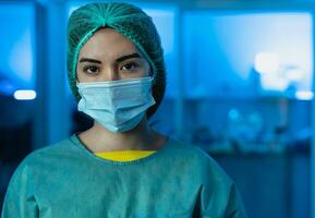 Young female doctor wearing personal protective equipment inside medical laboratory during corona virus pandemic - Health care worker concept photo