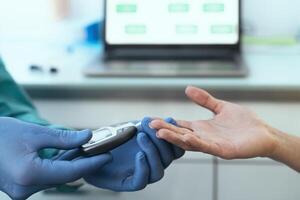 Close up medical worker checking glycemia test for diabetes to female patient during corona virus outbreak photo