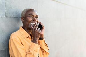 africano mayor mujer haciendo un llamada con móvil teléfono inteligente mientras de fumar cigarrillo foto