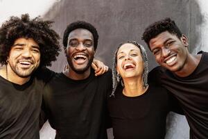 Happy group of multiracial people having fun laughing in front of camera outdoor photo