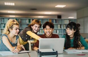 Young university students using laptop and studying with books in library - School education concep photo