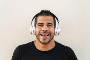 Hispanic man listening music with headphones outdoor photo