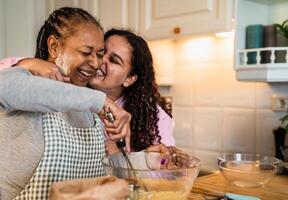 contento africano madre y hija teniendo divertido preparando un hecho en casa postre foto