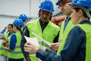 Team of multiracial engineers working in robotic factory - Tech industry concept photo