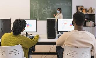 Young students listening a lesson in high school while wearing face mask during corona virus pandemic - Education and technology concept photo