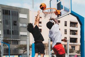 joven africano americano hombres jugando baloncesto al aire libre - urbano deporte estilo de vida concepto foto