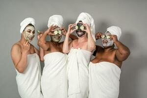 Happy multiracial females with different body size having skin care spa day - People selfcare concept photo