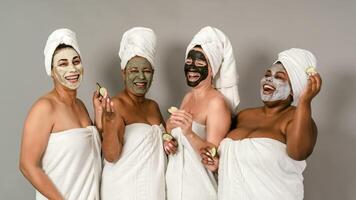 Happy multiracial females with different age and body size having skin care spa day - People selfcare concept photo