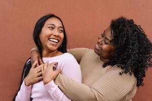 Happy Latin girls having fun embracing outdoor - Young people lifestyle and friendship concept photo