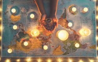 Top view female hands planning vacation tour equipped with world map and vintage nautical compass - Travel adventure lifestyle people and discovering destinations concept photo