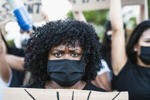 joven afro mujer activista protestando en contra racismo y luchando para igualdad - negro vive importar demostración en calle para justicia y igual derechos foto