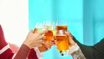 Happy friends doing celebratory toast in winter Christmas holidays - Young people drinking beer in xmas time - Youth culture lifestyle and traditional event celebration concept photo