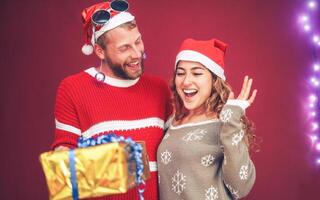 contento Pareja celebrando Navidad hora compartiendo regalos - joven personas teniendo divertido durante Navidad Días festivos - Navidad vacaciones y tradicional cultura estilo de vida concepto foto