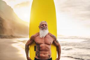 contento ajuste mayor teniendo divertido surf a puesta de sol hora - deportivo barbado hombre formación con tabla de surf en el playa - mayor sano personas estilo de vida y extremo deporte concepto foto