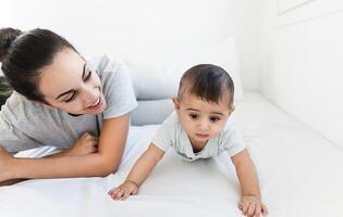 Happy mother lying on bed with her little baby - Family and Maternity concept photo