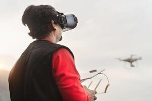 Male professional pilot doing fpv experience using virtual reality glasses and drone - Technology and innovation concept photo