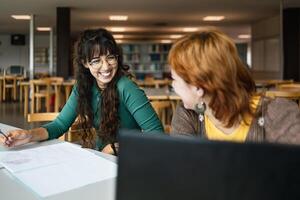 Young girls studying in library - School education concept photo