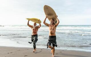 contento amigos con diferente años surf juntos - deportivo personas teniendo divertido durante vacaciones navegar día - extremo deporte estilo de vida concepto foto