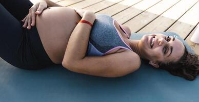 Happy pregnant woman caressing her belly outdoor - Health lifestyle and maternity concept photo