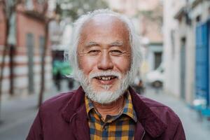 retrato de contento asiático mayor hombre sonriente en frente de cámara foto