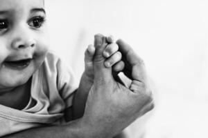 Close up of little baby holding mother thumb - Family and maternity concept - Black and white editing photo