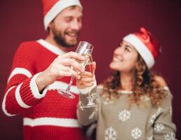 Happy couple drinking champagne during christmas time - Young millennial people having fun celebrating xmas holidays together - Love, relationship and youth lifestyle photo