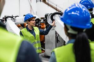 Team of engineers working in robotic factory - Tech industry concept photo