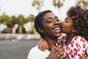 Happy African family on the beach during summer holidays - Afro American people having fun on vacation time - Parents love unity and travel lifestyle concept photo