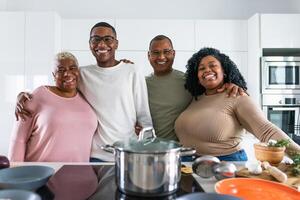 Happy Hispanic family having fun cooking together in modern kitchen - Food and parents unity concept photo