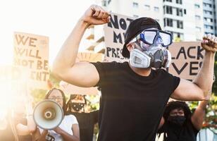 Activist movement protesting against racism and fighting for equality - Demonstrators from different cultures and race protest on street for equal rights - Black lives matter protests city concept photo