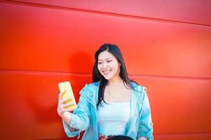 Happy asian influncer using mobile smart phone outdoor - Chinese fashion girl watching on new trends social networks - Web influencing, millennials, technology and generation z concept photo
