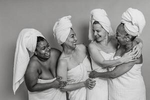 Happy multiracial women with different ages and body size having skin care spa day - People wellness and selfcare concept - Black and white editing photo