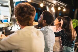 Happy multiracial people buying meal from food truck kitchen - Modern business and take away concept photo