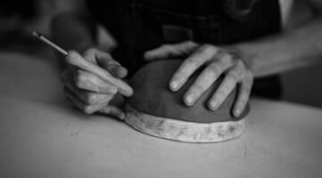 Close up female potter modeling clay bowl in workshop - Artisan work and creative craft concept - Black and white editing photo