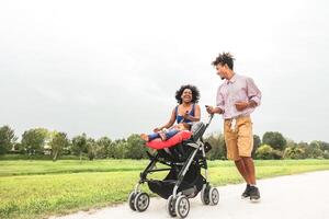 contento africano familia teniendo divertido juntos en público parque - afro madre y padre con su hija disfrutando hora juntos durante fin de semana al aire libre - padres amor y de la madre día concepto foto