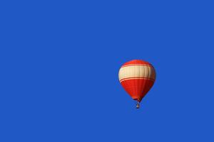 A red balloon floats on blue sky background in Vang Vieng, Laos photo