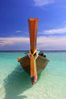 Traditional Thai Long tail boat on the Lipe beach, Lipe island. Satun Province Thailand photo