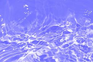 Bluewater waves on the surface ripples blurred. Defocus blurred transparent blue colored clear calm water surface texture with splash and bubbles. Water waves with shining pattern texture background. photo