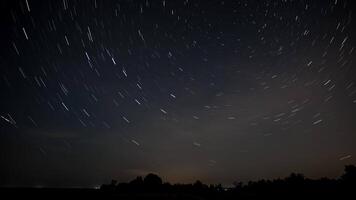 Stars move around a polar star. Time lapse of Star trails in the night sky. 4K video