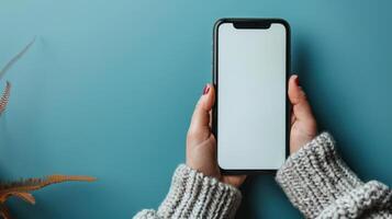 AI generated Close-up hand holding a phone with a blank white screen turned towards the camera. blue background photo