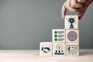 Concepts and methods for developing organizations towards success. Business icons on wooden blocks represent establishing strategy and implementing plan. with copy space photo