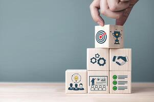 Concepts and methods for developing organizations towards success. Business icons on wooden blocks represent establishing Strategy and Implementing plan. with copy space photo