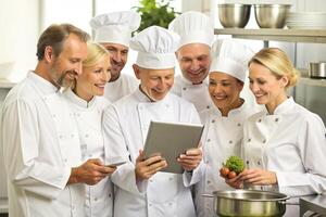 ai generado moderno cocina equipo cocineros tableta foto