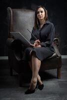 a young brunette female artist stands behind an easel. photo