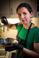 Woman cooking tasty melted chocolate on table in kitchen. photo